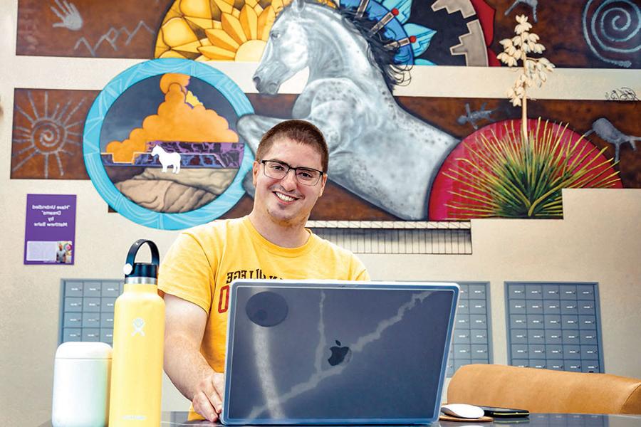 Student Nate Schirer sits at his computer in the SJC Housing.