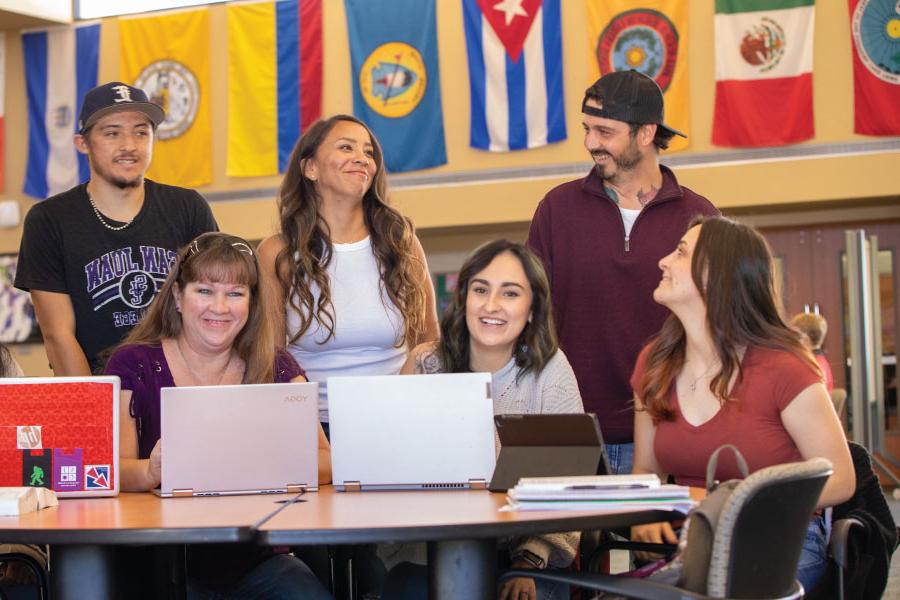 Grupo de estudiantes sentados en una mesa riendo